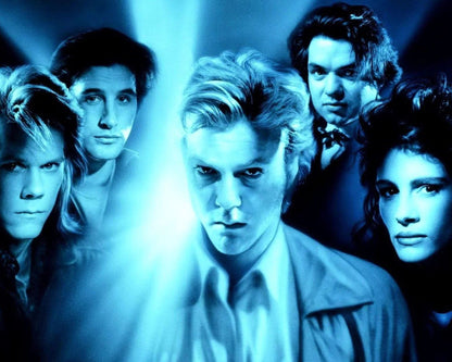 A blue-toned promotional still featuring five people posed together against a glowing light burst. The central figure is in front, with four others partially visible behind him in a dramatic, high-contrast scene.