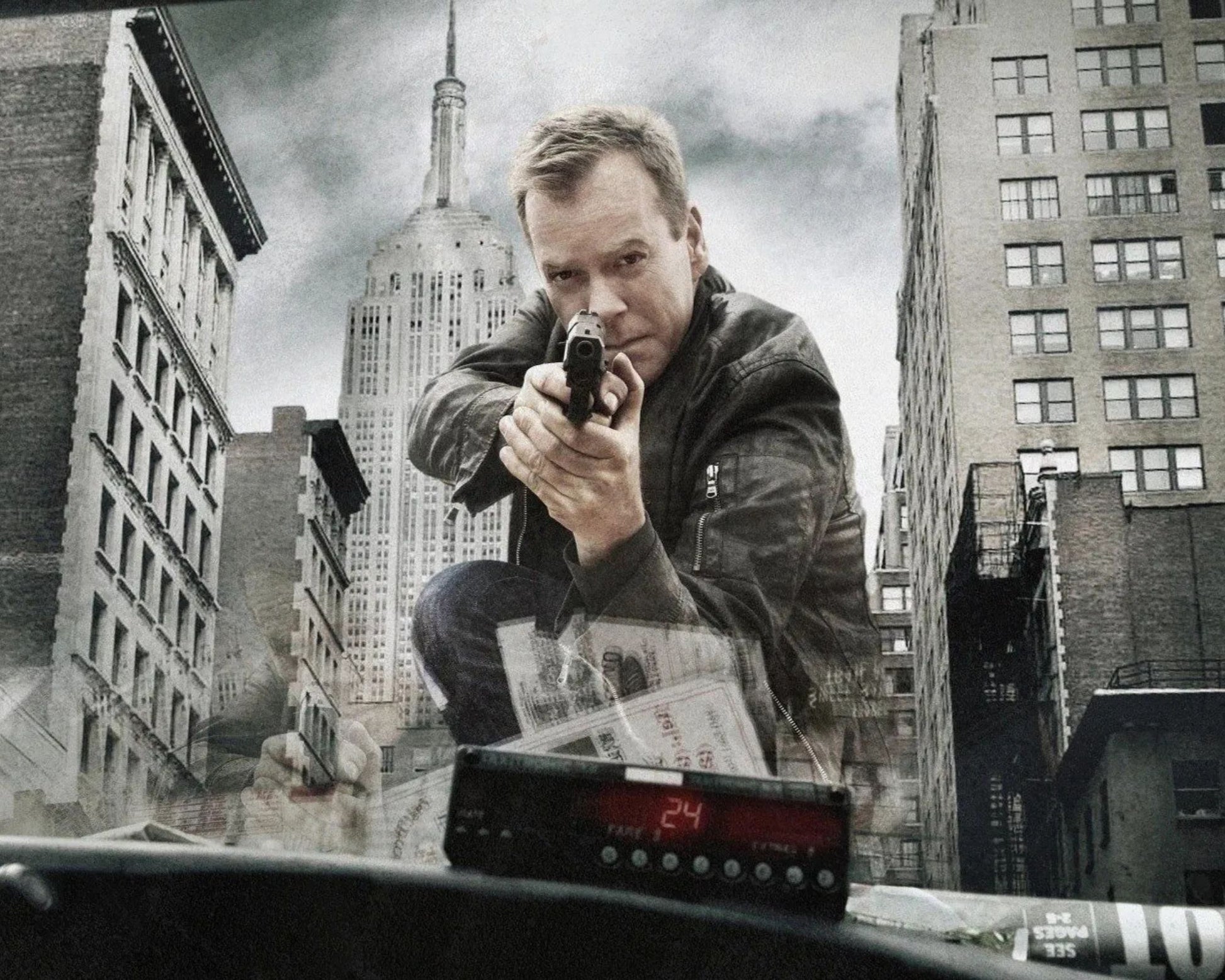 A dramatic poster-style scene showing a man crouching in front of a car windshield in a city, holding a handgun, with buildings and the Empire State Building in the background.