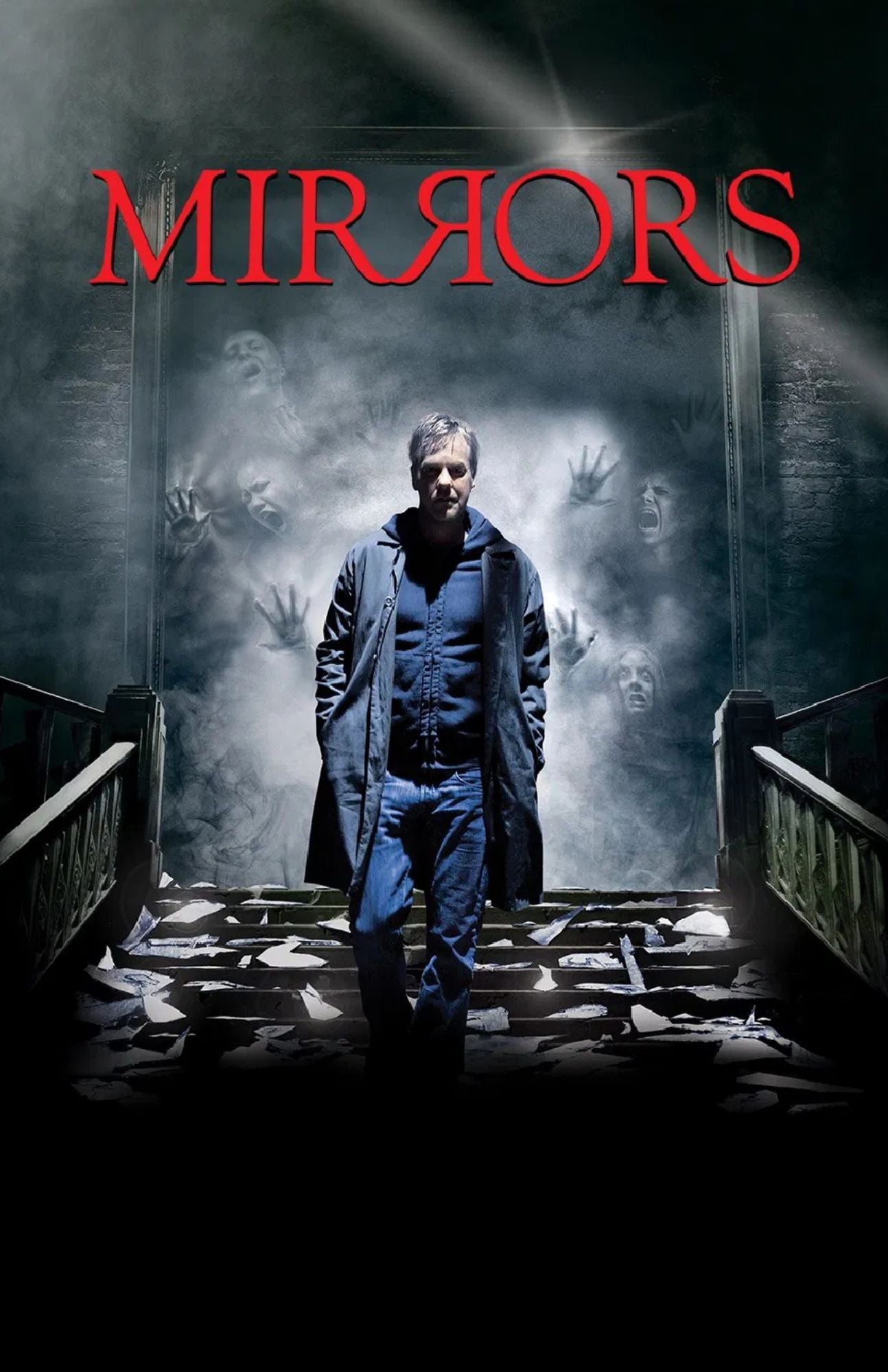 Movie poster for 'Mirrors' featuring a man in a dark coat and jeans standing in a stairwell, with ghostly faces reflected in mirrors behind him and the title 'MIRRORS' in large red letters at the top.