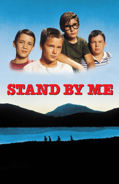 Movie poster for 'Stand By Me' featuring four young boys against a blue sky, with the title in large red letters above a dark mountain and lake landscape.